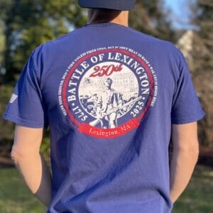 Man wearing Lexington battle commemorative t-shirt outdoors.